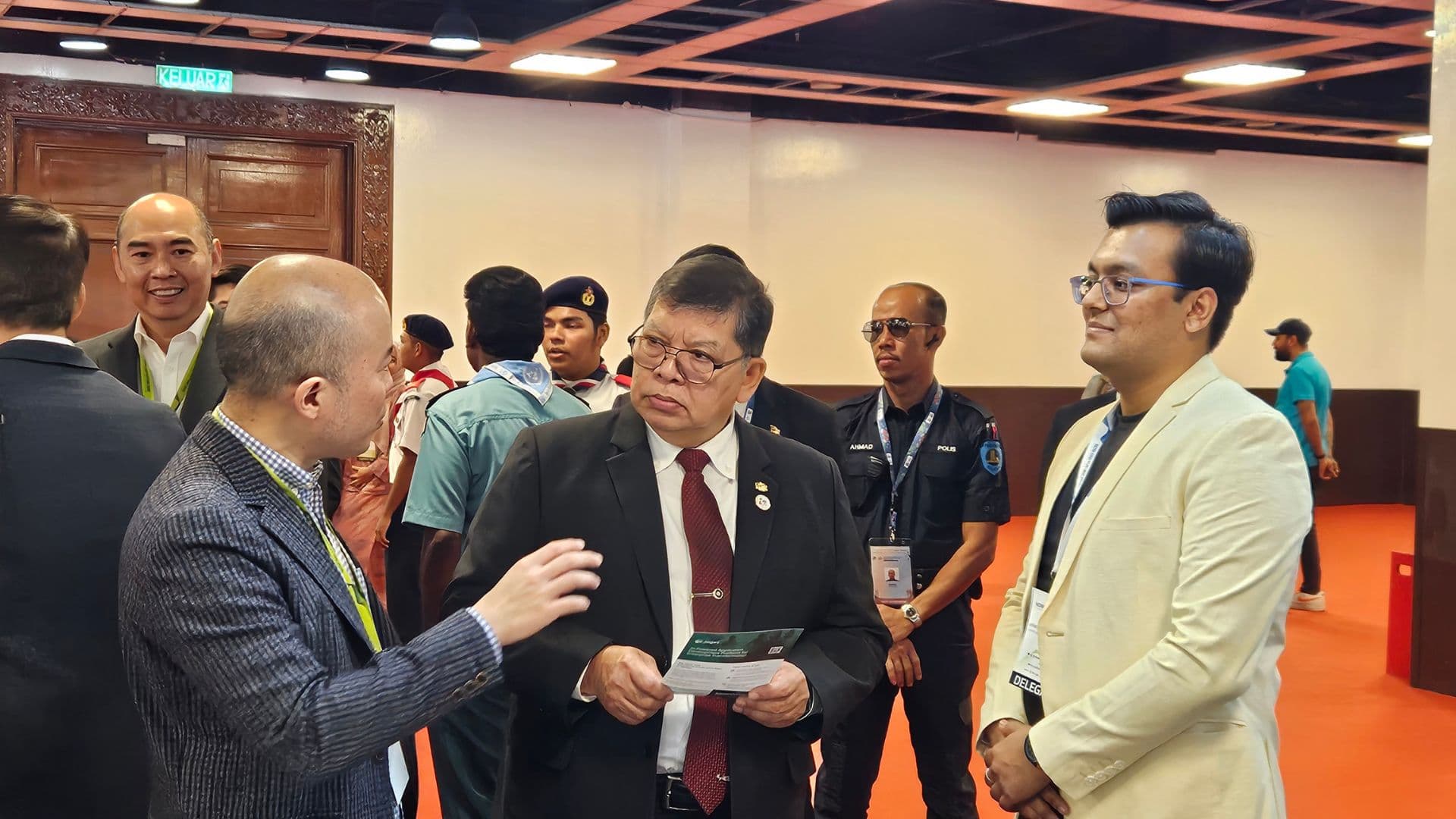 The Speaker of Malaysia's House of Representatives, holding a Joget brochure, in conversation at the Joget booth while Anchit Shrivastava looks on.